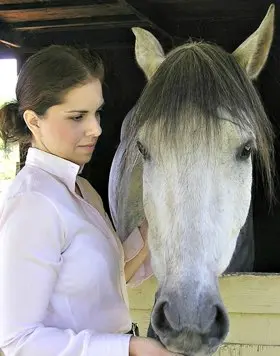 Mimi Matthews standing next to her horse, Centelleo